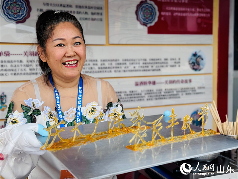 장인이 설탕을 필로 사용하여 2025년 중국농민풍수절에 대한 달콤한 축복을 그리고 있다(인민넷 정흔교 촬영).