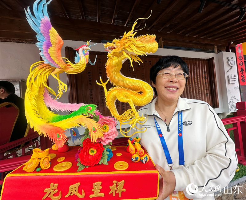 산동 청도 왕가장 대형찐빵 제작자가 찐빵조각품을 전시하고 있다(인민넷 교주 촬영).