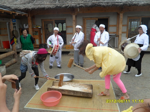 观光客们在体验朝鲜族传统糕点打糕的制作관광객들이 조선족 전통음식인 찰떡을 만드는 체험을 하고있다